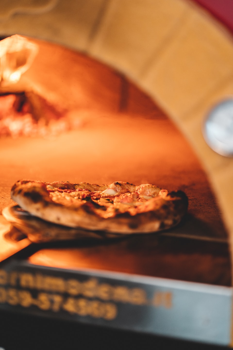 Malá pizza s bublajúcimi oblohami v horúcej tehlovej peci.